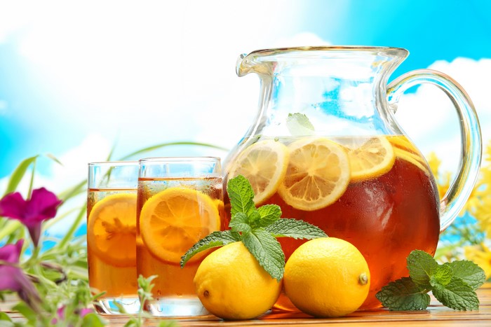 Pitcher and glasses of iced tea with lemons and mint