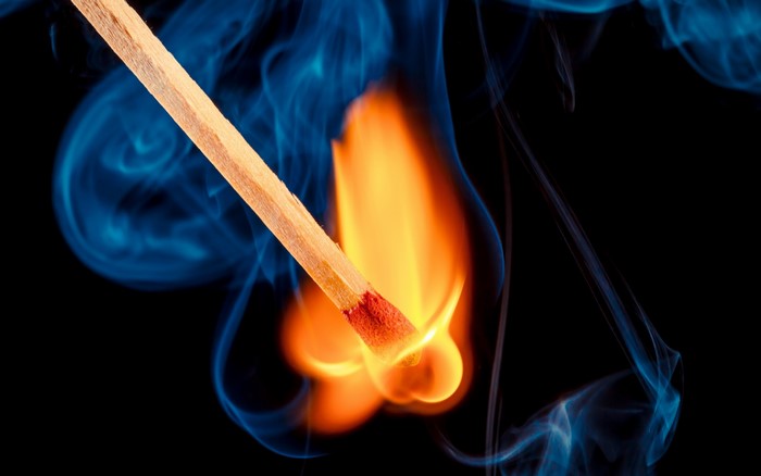 Burning match with blue smoke