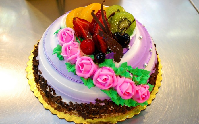 Fruit decorated cake with pink roses