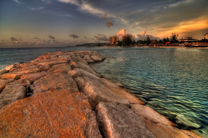 Jamaica resorts on a rocky coastline at sunset