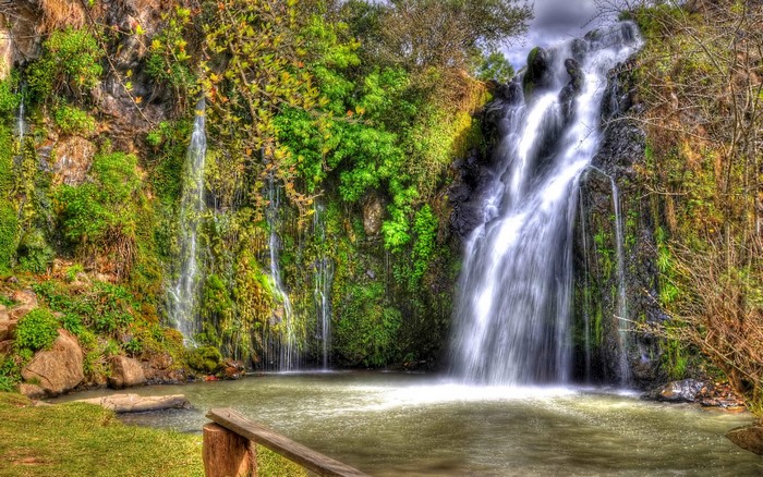 Waterfalls cascading down mossy rocks into a pool