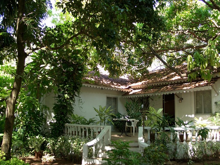 White house with tiled roof and lush greenery in India