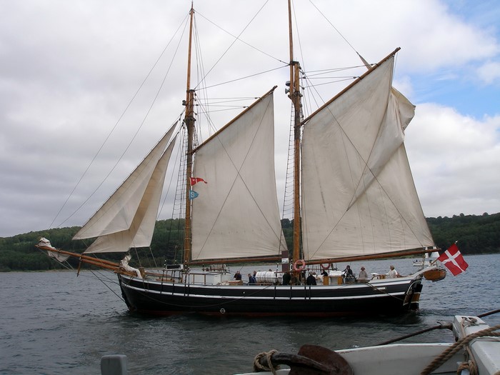 Sailing ship with white sails and Danish flag