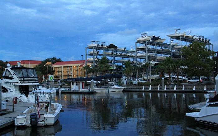 Boats docked at a marina with a boat storage rack