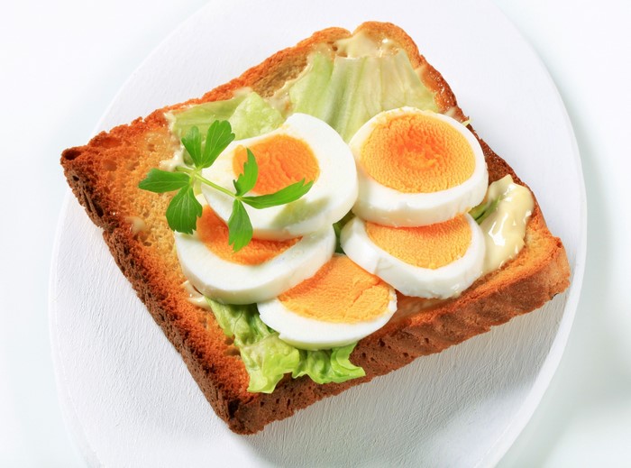 Toast with sliced hard-boiled eggs and lettuce