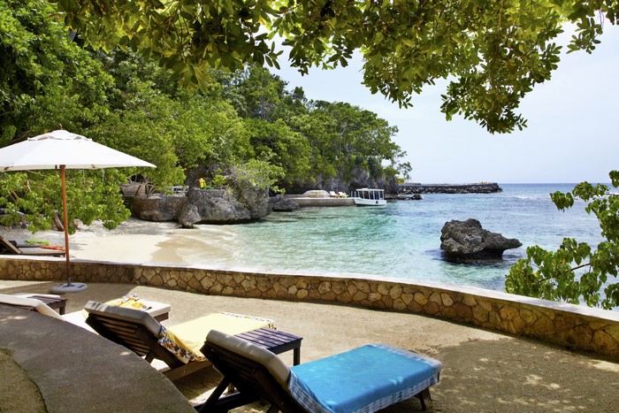 Tropical beach with lounge chairs and boat in Jamaica