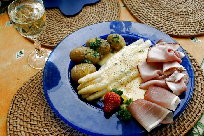 White asparagus with potatoes, ham, and strawberry
