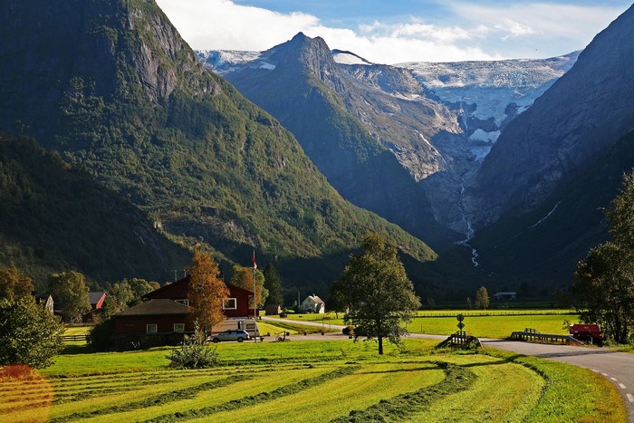 Farmhouse in a valley with a glacier in the background