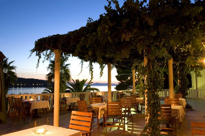 Outdoor restaurant terrace with sea view at dusk