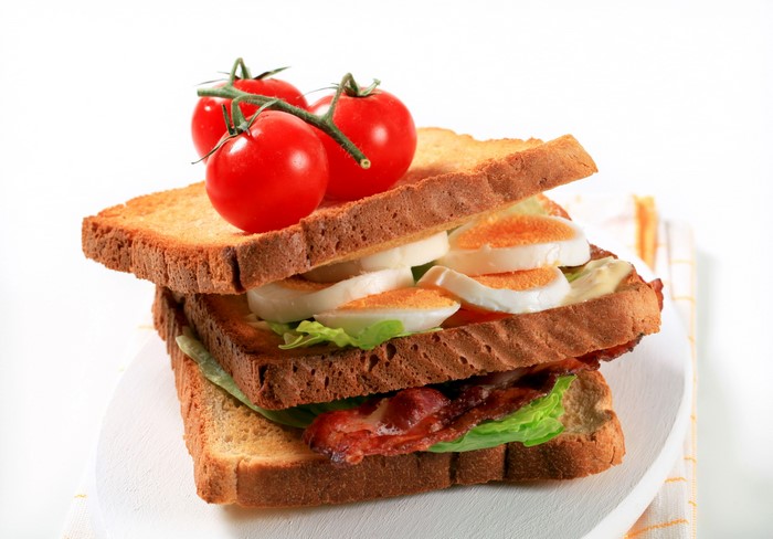 Sandwich with bacon, egg, lettuce, and tomatoes