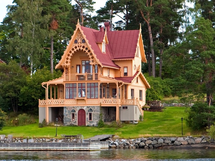Ornate wooden house with red roof by the water in Vaxholm, Sweden