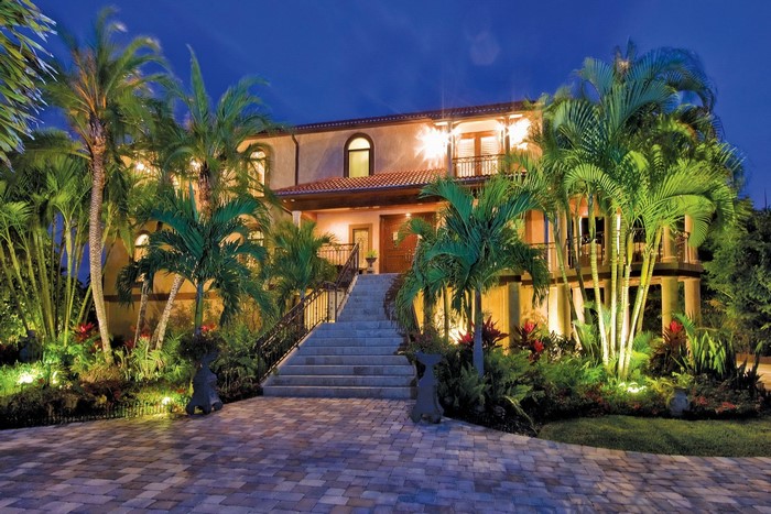 Luxury Mediterranean villa with palm trees at night