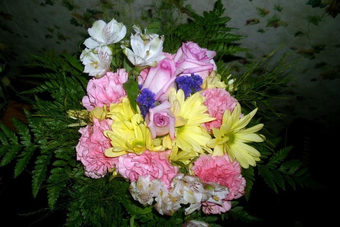 Bouquet of pink carnations, yellow daisies, and purple roses