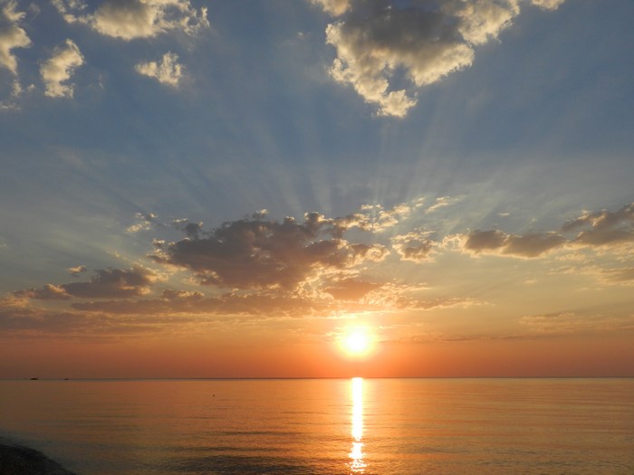 Sunset over the ocean with sun rays