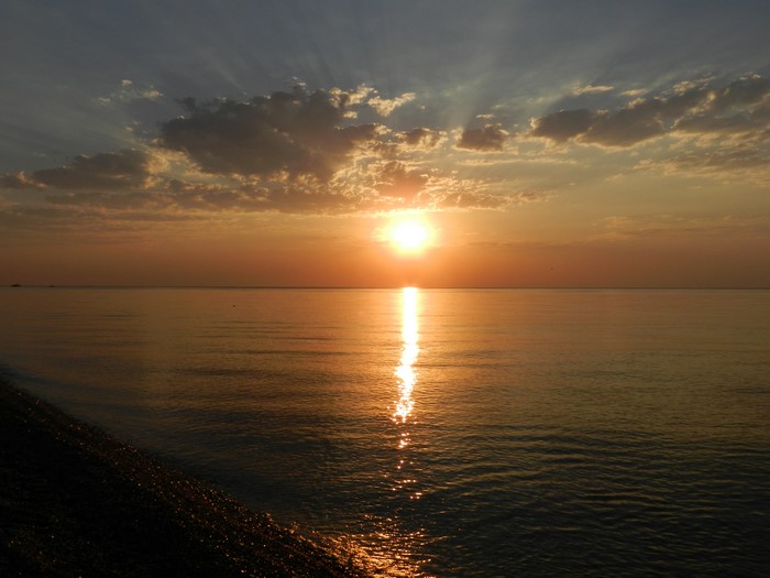 Sunset over the ocean with sun rays