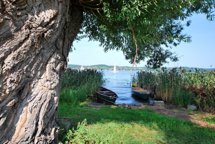 Boats on a lake with sailboats in the distance
