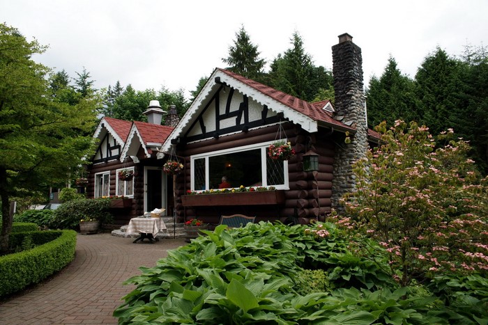 Log cabin with stone chimney and garden in Vancouver, Canada
