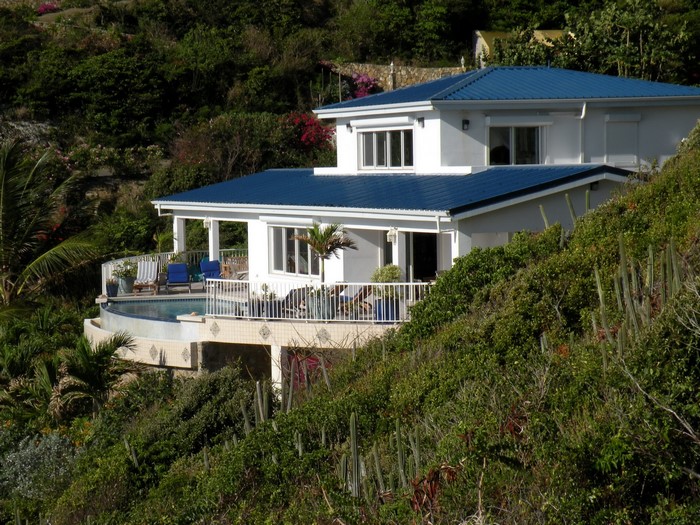 White house with blue roof on a hillside