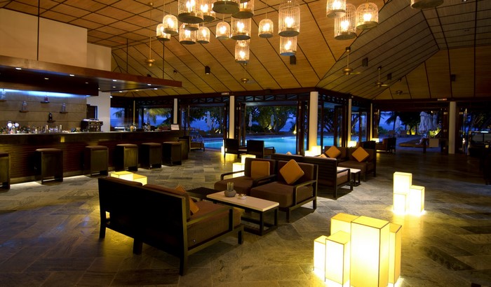 Interior of a resort lobby with a bar and pool view