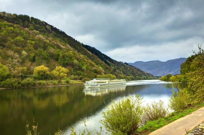 Cruise ship on a river with forested hills