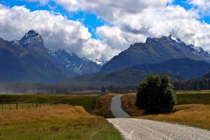 Gravel road leading to snow-capped mountains
