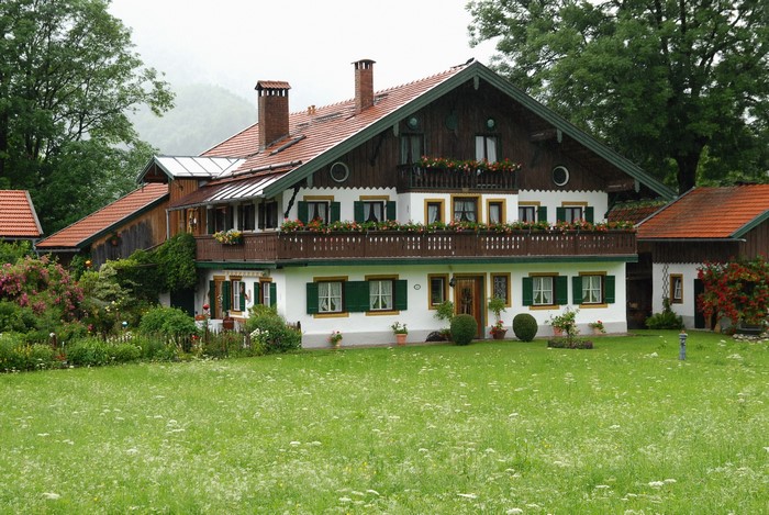 Traditional German house with a flower-filled balcony and garden