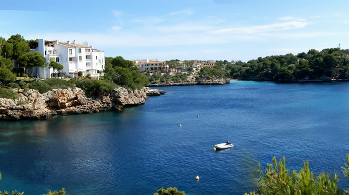Coastal bay with white buildings and trees in Mallorca, Spain
