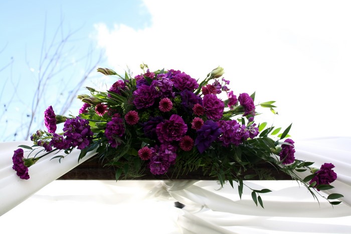 Purple floral arrangement on white fabric