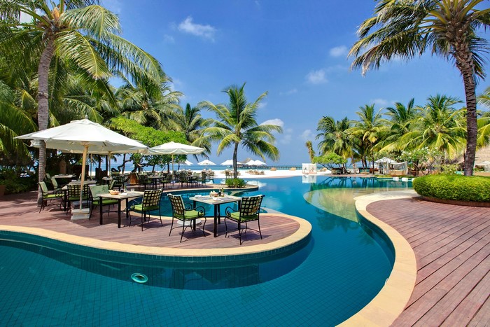 Resort swimming pool with palm trees and beach
