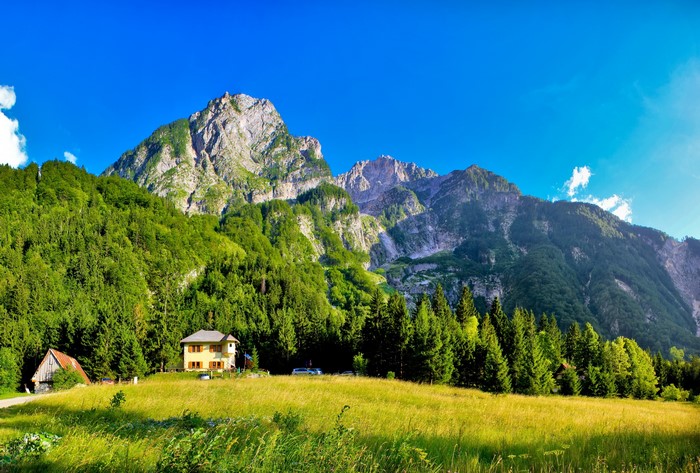 Yellow house and barn in front of mountains