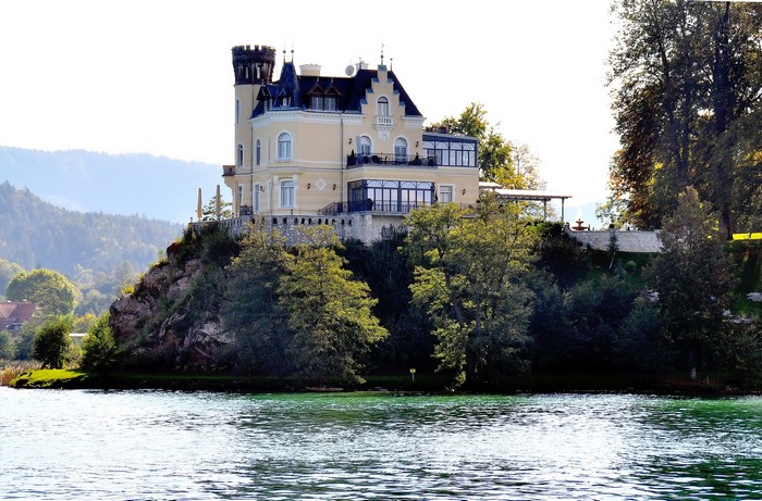 Schloss Reifnitz castle on a cliff overlooking a lake in Austria