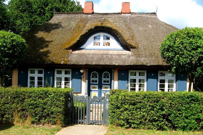 Thatched roof house in Germany with blue shutters