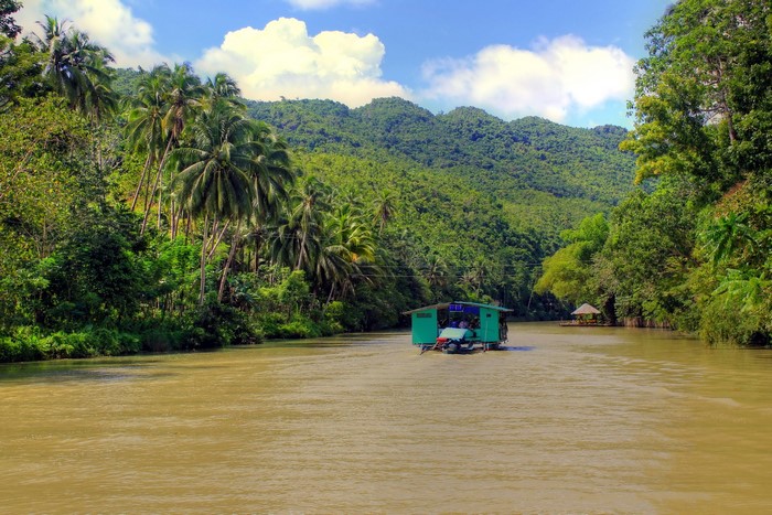 River cruise through a tropical jungle with mountains
