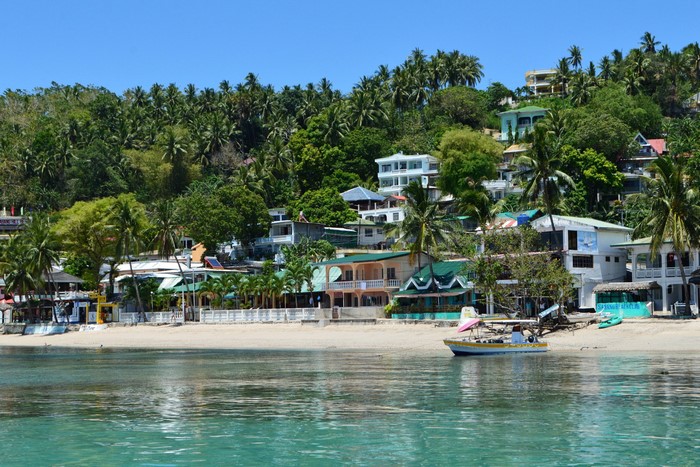 Tropical beach with houses and palm trees
