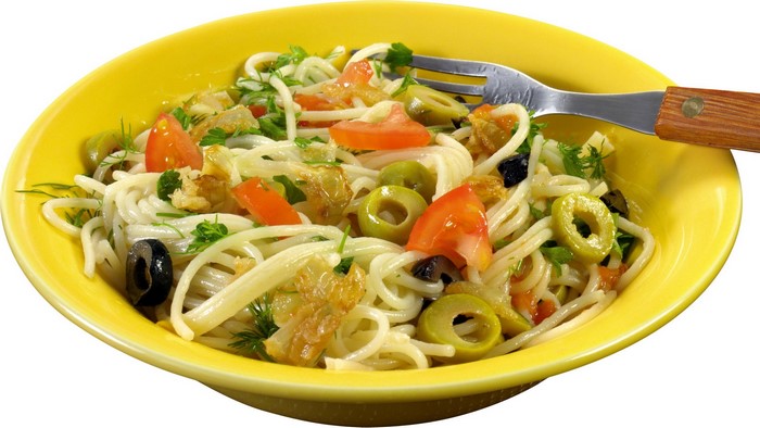 Spaghetti with tomatoes, olives, and herbs in a yellow bowl