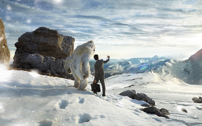 Man taking a selfie with a yeti in snowy mountains