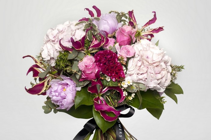 Bouquet of pink and purple flowers with a black ribbon
