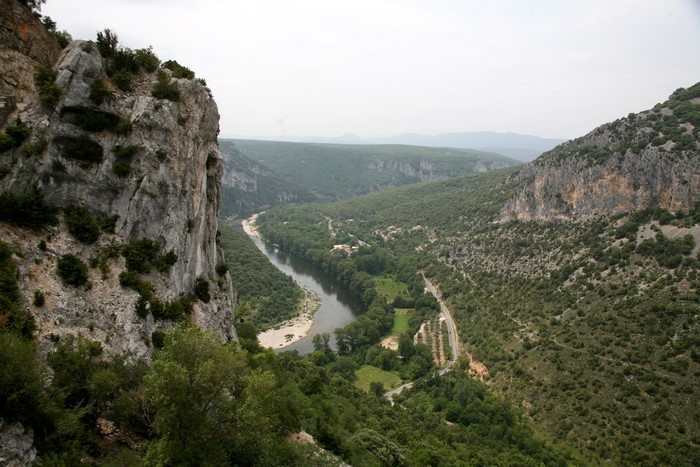 River flowing through a forested canyon with rocky cliffs