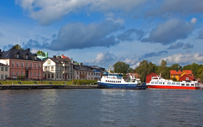 Boats docked by buildings in Vaxholm, Sweden