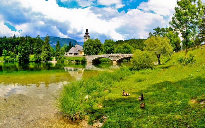 Church and bridge over a lake in Bohinj, Slovenia