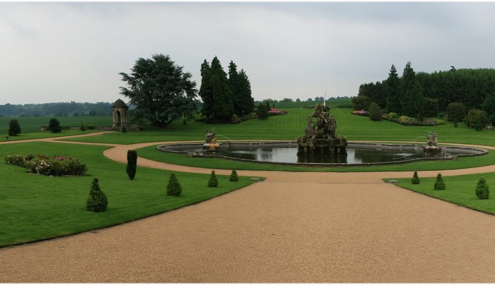 Formal gardens with a large fountain and manicured lawns