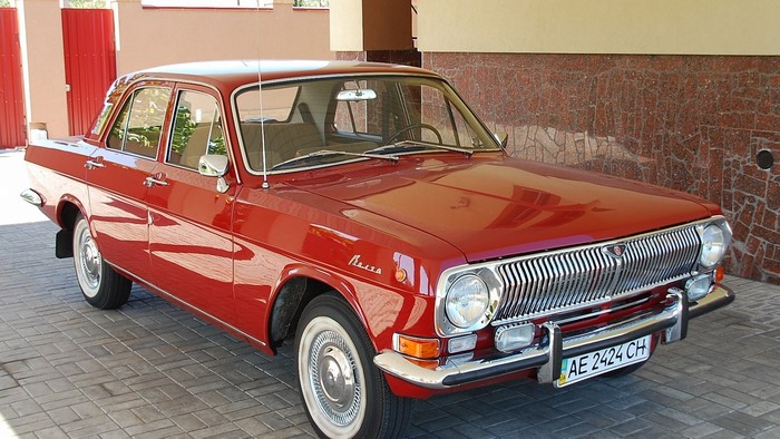 Red GAZ-24 Volga sedan parked on a paved driveway