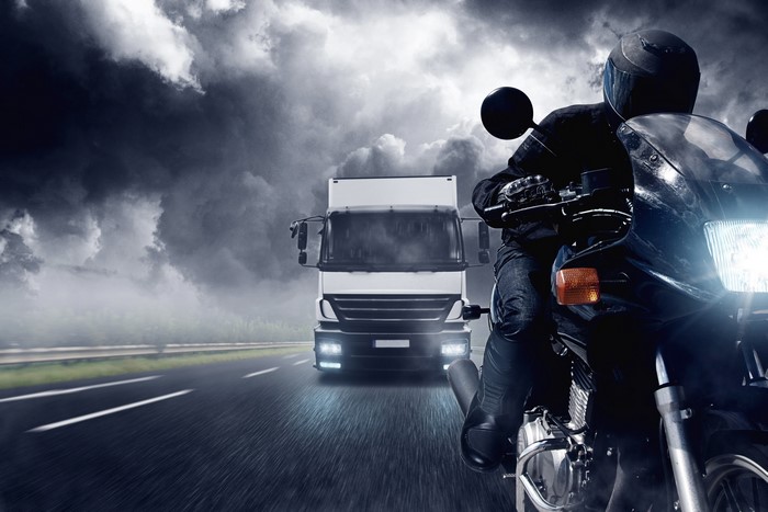 Motorcyclist and Truck on a Stormy Road