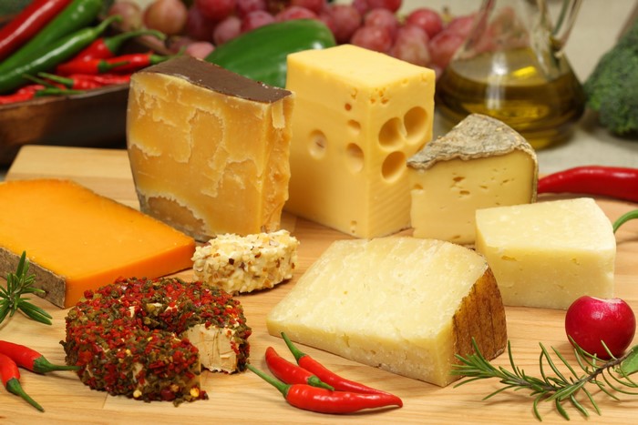 Assortment of cheeses with chili peppers and rosemary