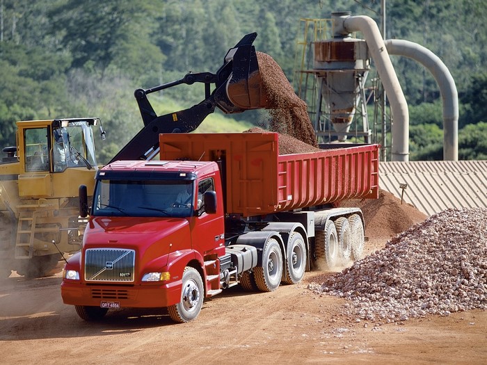 Volvo truck being loaded by excavator