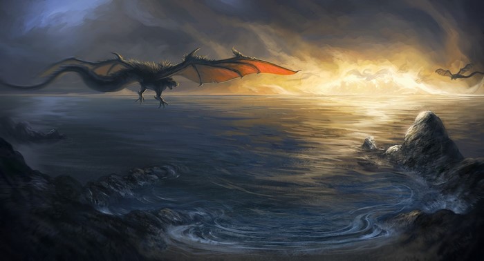Dragons flying over the ocean at sunset