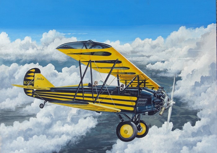 Yellow and black Travelaire biplane flying through clouds