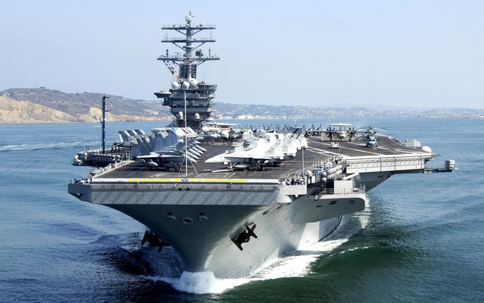 Aircraft carrier sailing in the ocean with airplanes on deck