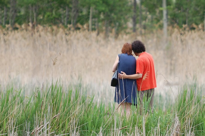 Couple walking through tall grass