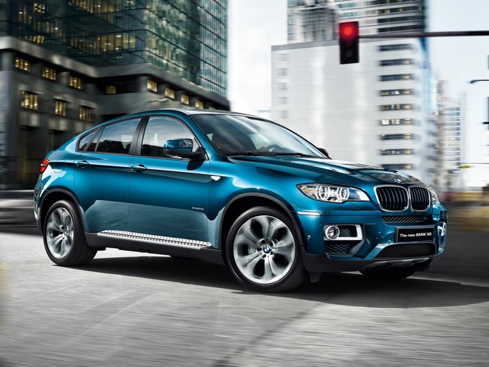 Blue BMW X6 driving in a city